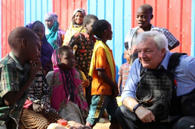UN Humanitarian Chief Stephen O'Brien, right, meets with drought affected people during his visit to one of Mogadishu IDP camps in Somalia, March 6, 2017.